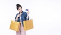 Excited cheerful shopper asian woman wear jacket jeans holding shopping bags paper pointing credit card mockup standing over Royalty Free Stock Photo