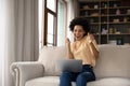 Excited cheerful young Black woman using laptop computer Royalty Free Stock Photo