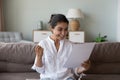 Excited cheerful young Indian woman getting good news letter