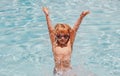 Excited child boy in sunglasses splashing in pool . Kid boy swim in swimming pool. Royalty Free Stock Photo
