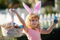 Excited child with easter basket. Easter bunny child boy with cute face. Kids hunting easter eggs. Happy easter holiday.