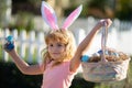 Excited child with easter basket. Easter bunny child boy with cute face. Kids hunting easter eggs. Happy easter holiday.