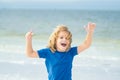 Excited child running in the summer sea. Cute kid run on summer sea. Funny expressive emotional boy running on summer