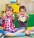 Excited children holding thumbs up