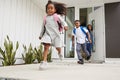 Excited Children Running Out Of Front Door On Way To School Watched By Mother Royalty Free Stock Photo