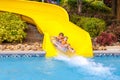 Excited children in water park riding on slide with float Royalty Free Stock Photo