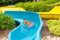 Excited children in water park riding on slide with float Royalty Free Stock Photo