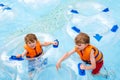 Excited children in water park riding on slide with float Royalty Free Stock Photo