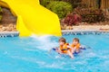 Excited children in water park riding on slide with float Royalty Free Stock Photo