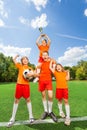 Excited children with won cup stand in pyramid Royalty Free Stock Photo