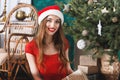 Excited Christmas Woman Wearing Santa Hat Sitting Near The New Year Spruce Royalty Free Stock Photo