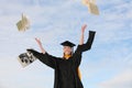 Excited college graduate tossing textbooks into air