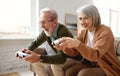 Excited senior couple playing video console games at home Royalty Free Stock Photo