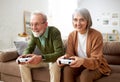 Excited senior couple playing video console games at home Royalty Free Stock Photo