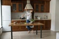 Excited cook blogger girl dancing to music at kitchen table