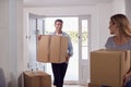 Excited Couple Carrying Boxes Through Front Door Of New Home On Moving Day Royalty Free Stock Photo