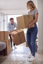 Excited Couple Carrying Boxes Through Front Door Of New Home On Moving Day Royalty Free Stock Photo