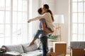 Excited couple celebrating moving day, man lifting embracing hap Royalty Free Stock Photo