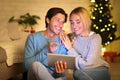 Excited couple choosing gifts for parents, using digital tablet Royalty Free Stock Photo