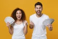 Excited couple friends european guy african american girl in white t-shirts isolated on yellow background. People Royalty Free Stock Photo