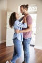 Excited Couple Hugging By Open Front Door In Lounge Of New Home Royalty Free Stock Photo