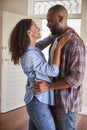 Excited Couple Hugging By Open Front Door In Lounge Of New Home Royalty Free Stock Photo