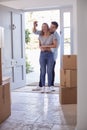 Excited Couple With Keys To New Home Standing By Front Door On Moving Day Royalty Free Stock Photo