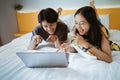 couple relaxing on bed using the laptop at home in the bedroom Royalty Free Stock Photo