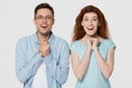 Excited couple looking at camera with delight isolated on background Royalty Free Stock Photo