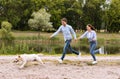 Excited couple and retriever running in countryside Royalty Free Stock Photo