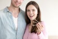 Excited couple showing new keys in focus, real estate purchase