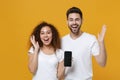 Excited couple two friends european guy african american girl in white t-shirts isolated on yellow background. People Royalty Free Stock Photo