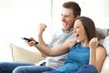 Excited couple watching tv on couch