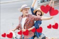 Excited couple waving hands while riding scooter Royalty Free Stock Photo