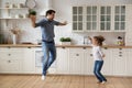 Excited crazy dad teaching daughter girl to dance at home