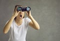 Excited curious woman looking through binoculars spying and trying to find out secrets. Royalty Free Stock Photo