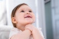 Excited cute little baby girl thinking of something dreaming or having a good idea, smiling and looking up, imagination. Royalty Free Stock Photo