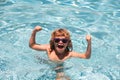 Excited cute little boy in sunglasses in pool in sunny day. Child relax in summer swimming pool. Royalty Free Stock Photo