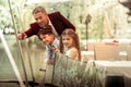 Excited cute son and daughter looking at ducks in lake with father Royalty Free Stock Photo