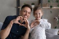 Excited dad and girl making hand hearts at camera