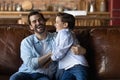 Excited dad and son having fun at home, enjoying playtime