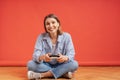 Excited casual young woman playing video games having fun on red background Royalty Free Stock Photo