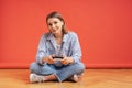 Excited casual young woman playing video games having fun on red background Royalty Free Stock Photo