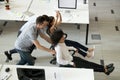 Excited employees have fun racing on chairs in office Royalty Free Stock Photo