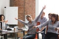 Excited diverse employees have fun riding chairs in office Royalty Free Stock Photo