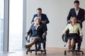 Excited diverse employees laughing riding on chairs in office Royalty Free Stock Photo