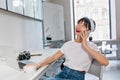 Excited dreamy girl with short hair speaking on phone during coffee break in office. Indoor portrait of cute brunette Royalty Free Stock Photo