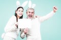 Excited Easter couple in bunny ears and rabbit costume on blue background isolated. Bunny couple celebrating easter