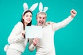 Excited Easter couple in bunny ears and rabbit costume on blue background isolated. Bunny couple celebrating easter Royalty Free Stock Photo