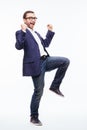 Excited elated happy young business man with beard in classic suit jumping and shouting over white background